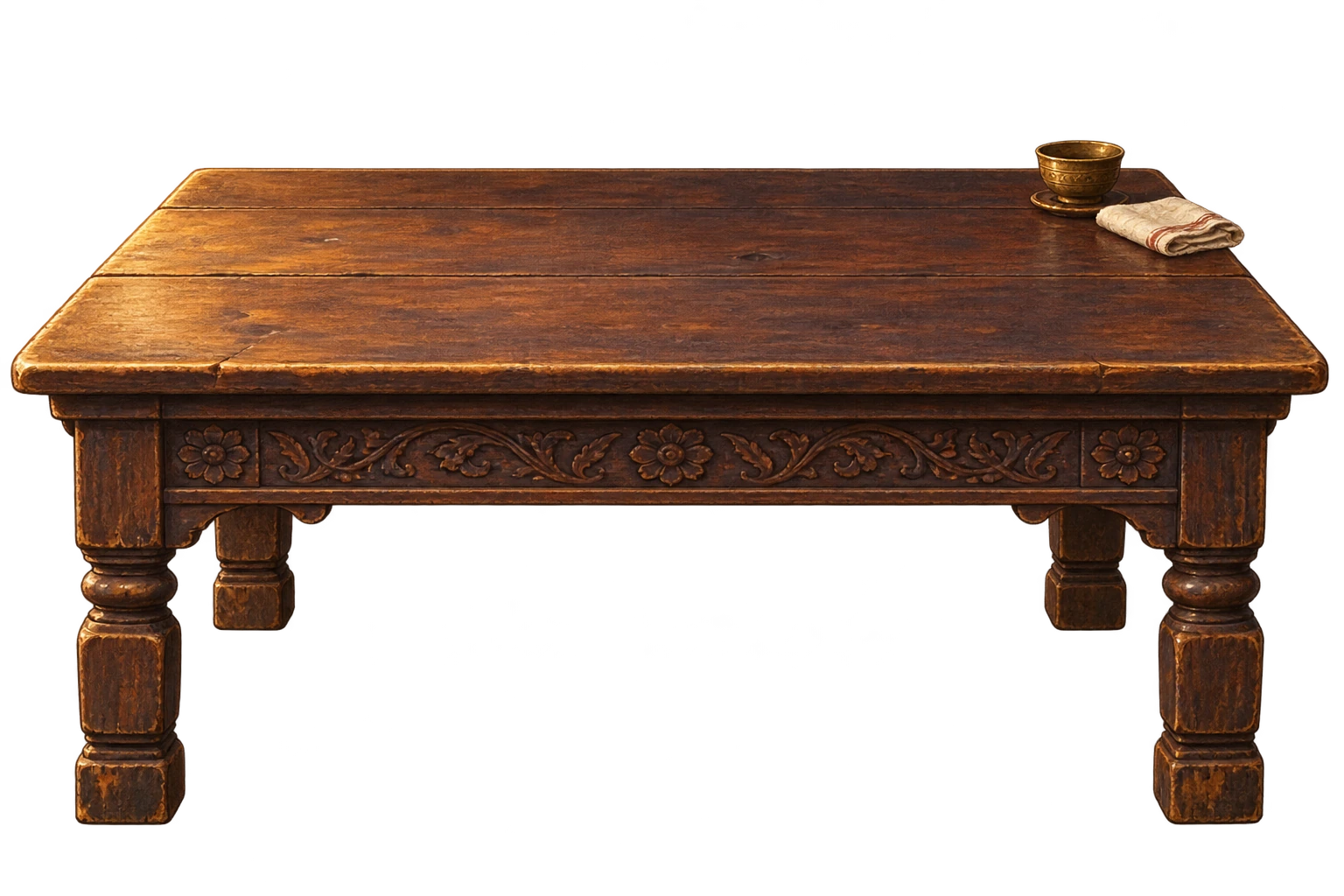 A worn carved wooden writing table with a brass cup